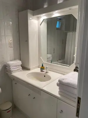 a bathroom with a sink and a mirror and towels at Blue Sky on the Sea Appartments in Athens