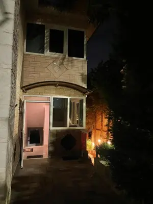 a house with an open door at night at Blue Sky on the Sea Appartments in Athens