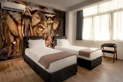 a hotel room with two beds and a wall mural at Pallada Athens boutique rooms & apartments in Athens