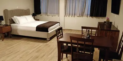 a bedroom with a bed and a table and chairs at Pallada Athens boutique rooms & apartments in Athens