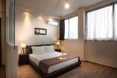 a bedroom with a bed and two windows at Pallada Athens boutique rooms & apartments in Athens