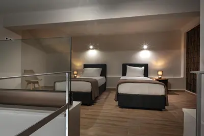 a hotel room with two beds and a balcony at Pallada Athens boutique rooms & apartments in Athens