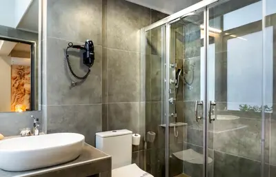 a bathroom with a sink and a shower at Pallada Athens boutique rooms & apartments in Athens