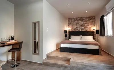 a bedroom with a bed and a brick wall at Pallada Athens boutique rooms & apartments in Athens