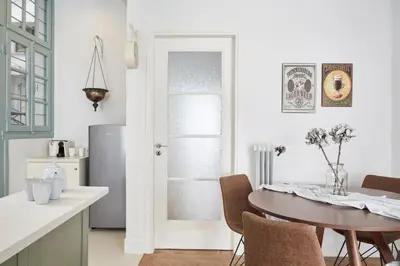 a kitchen and dining room with a table and a refrigerator at Luxury n Chic Athens Museum Apt in Athens
