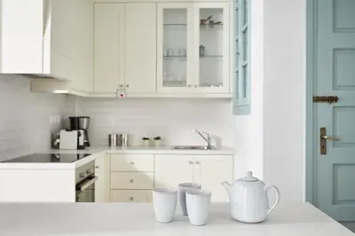 a kitchen with white cabinets and two tea cups on a counter at Luxury n Chic Athens Museum Apt in Athens