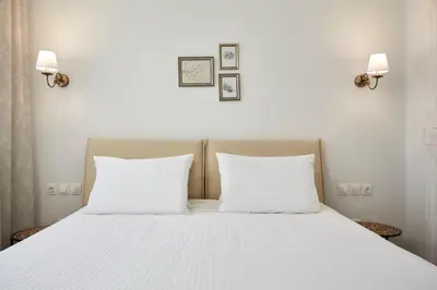 a bed with two pillows and two pictures on the wall at Luxury n Chic Athens Museum Apt in Athens