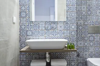 a bathroom with a sink and blue and white tiles at Luxury n Chic Athens Museum Apt in Athens
