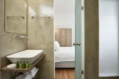 two images of a bathroom with a sink and a bedroom at Luxury n Chic Athens Museum Apt in Athens
