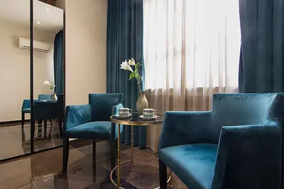 a room with blue chairs and a table and a window at Athens Imperial Suites - Luxury Living in Athens