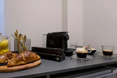 a table with two cups of coffee and some bread at Athens Imperial Suites - Luxury Living in Athens