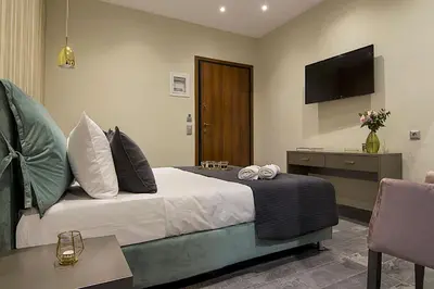 a hotel room with a bed and a television at Athens Imperial Suites - Luxury Living in Athens