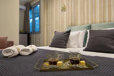 a tray with drinks and towels on a bed at Athens Imperial Suites - Luxury Living in Athens
