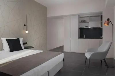 a bedroom with a bed and a chair in it at Azur Suites in Athens