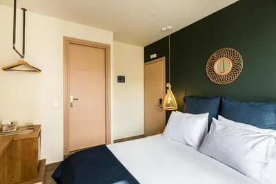a bedroom with a large bed with a green wall at Ciel Living Athens in Athens