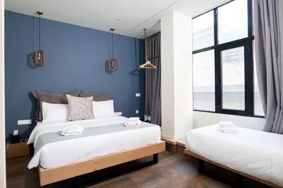 two beds in a room with blue walls at Ciel Living Athens in Athens