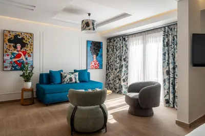 a living room with a blue couch and two chairs at Garment District Suites in Athens