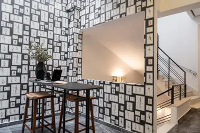 a room with a table and two chairs and a wall of photographs at Garment District Suites in Athens
