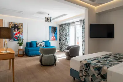 a hotel room with a bed and a blue couch at Garment District Suites in Athens