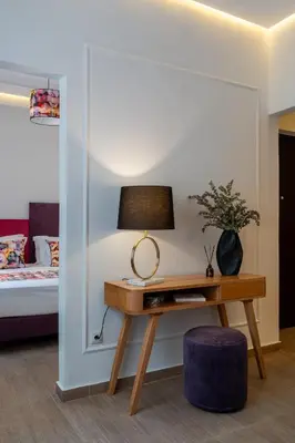 a room with a desk with a lamp and a bed at Garment District Suites in Athens