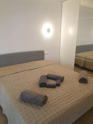 a bedroom with two towels on a bed with a mirror at Newly Renovated Varkiza Beachside One Bedroom with Large Terrace in Athens