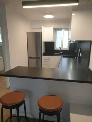 a kitchen with two stools and a counter top at Newly Renovated Varkiza Beachside One Bedroom with Large Terrace in Athens