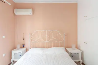 a bedroom with a white bed and two night stands at Maria's Home in Dhaskalión