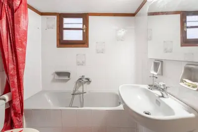 a white bathroom with a tub and a sink at Maria's Home in Dhaskalión