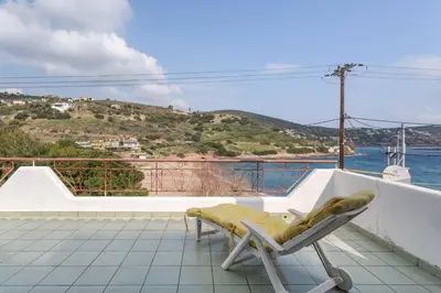 a chair on a balcony with a view of the ocean at Maria's Home in Dhaskalión