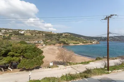 a road next to a beach with the ocean at Maria's Home in Dhaskalión