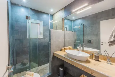 a bathroom with a sink and a glass shower at 100m2 Luxury Apartment in the Heart of Athens - Living Stone Emerald in Athens