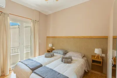 two beds in a room with a window at 100m2 Luxury Apartment in the Heart of Athens - Living Stone Emerald in Athens