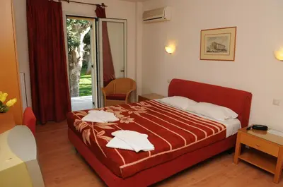 a bedroom with a bed with two towels on it at Hotel Pantheon in Markopoulo