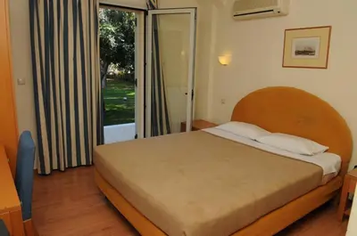 a bedroom with a bed and a large window at Hotel Pantheon in Markopoulo