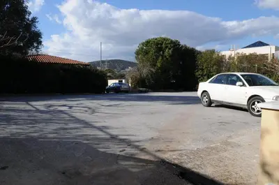 a white car parked in a parking lot at Hotel Pantheon in Markopoulo