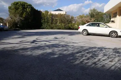 a white car parked in a parking lot at Hotel Pantheon in Markopoulo