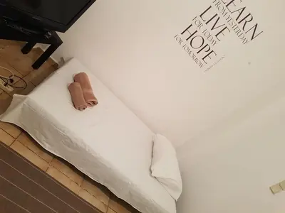 a bed with a pair of slippers on top of it at Filopappou Hill Apartment in Athens