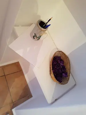 a basket of purple flowers on a white table at Filopappou Hill Apartment in Athens