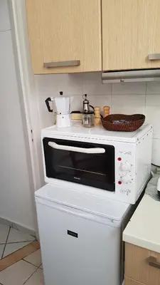 a microwave on top of a refrigerator in a kitchen at Filopappou Hill Apartment in Athens