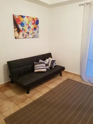 a black couch in a room with a painting on the wall at Filopappou Hill Apartment in Athens