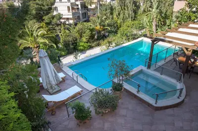 an overhead view of a swimming pool with chairs and an umbrella at Exceptional Villa in Voula near the sea in Athens
