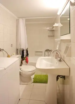 a white bathroom with a sink and a toilet at Kleisthenes' apartment in Athens