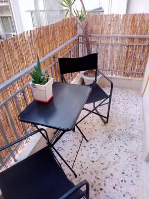 a black table and two chairs on a balcony at Kleisthenes' apartment in Athens