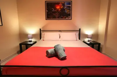 a bedroom with a bed with a red blanket at Kleisthenes' apartment in Athens
