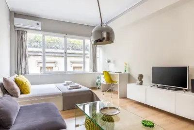 a white living room with a bed and a tv at Stay like a local next to Acropolis & Plaka! in Athens