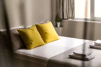 a couch with two yellow pillows on top of it at Stay like a local next to Acropolis & Plaka! in Athens