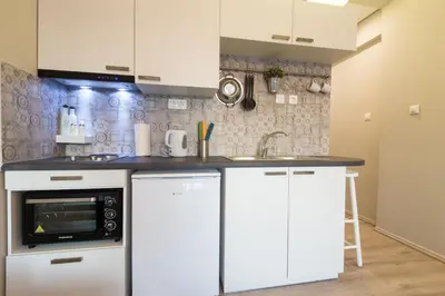 a kitchen with white cabinets and a microwave at Treat yourself w. this central City-break studio! in Athens