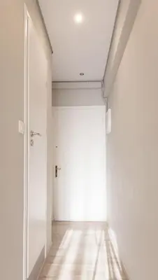 a hallway with a white door and a wooden floor at Treat yourself w. this central City-break studio! in Athens