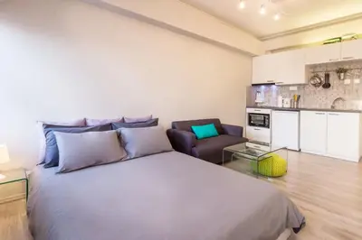a bedroom with a large bed and a couch at Treat yourself w. this central City-break studio! in Athens