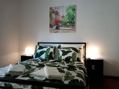 a bedroom with a bed with a green and white comforter at Afrodite's apartment (close to Athens city center) in Athens